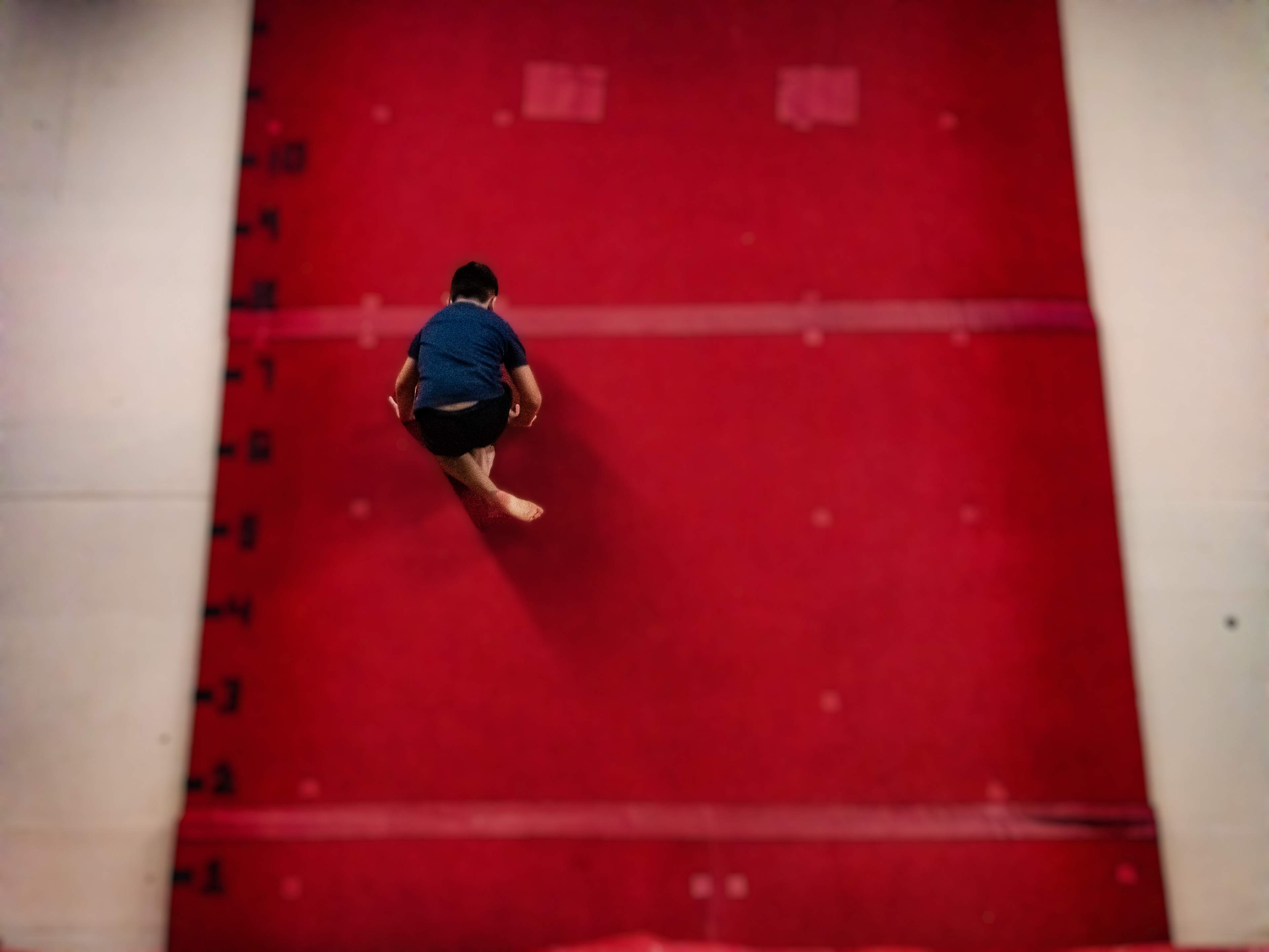 Athlete running up the trampoline wall