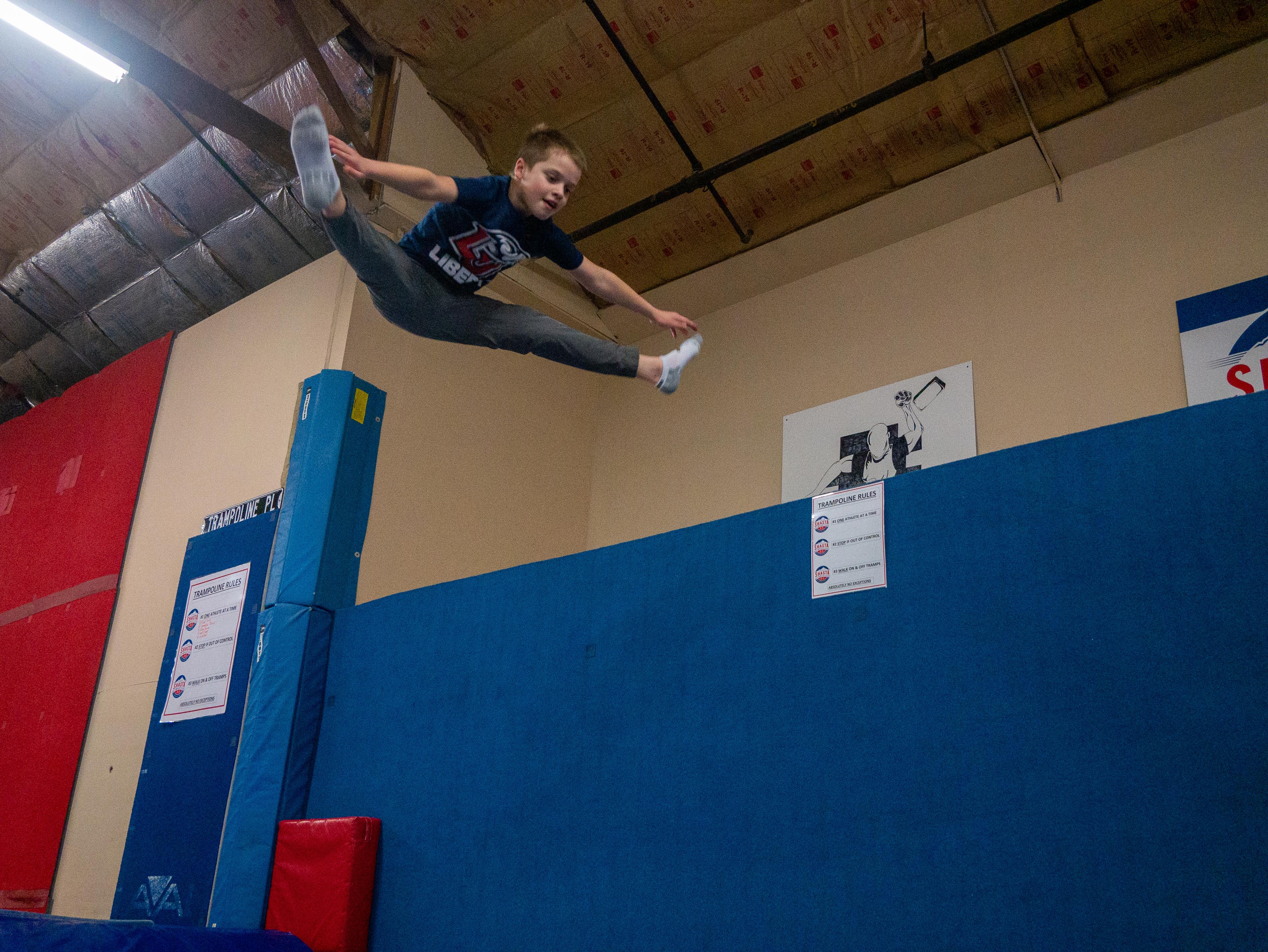 Athlete performing a straddle jump on trampoline